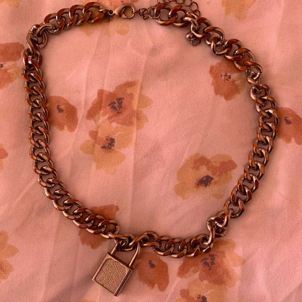 Slightly rusted metal chain with lock charm